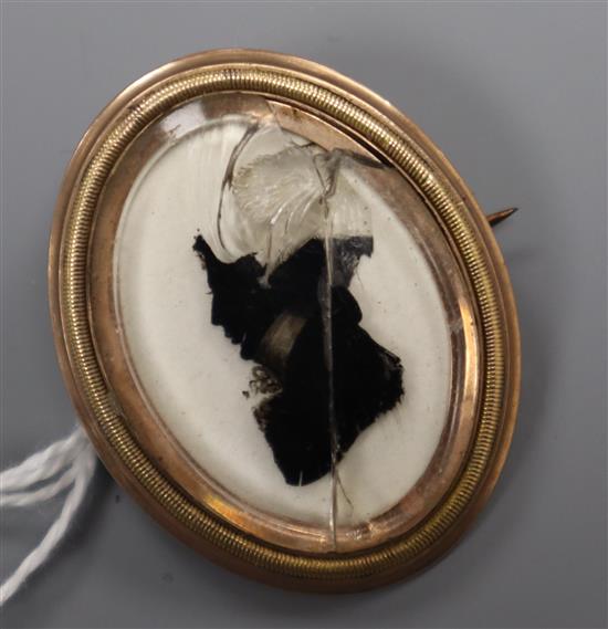 An early 19th century yellow metal framed silhouette brooch (damaged glass), 38mm.